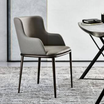 Superior Cattelan Italia Magda ML chair with enveloping silhouette in muted gray synthetic material and dark matte metal legs