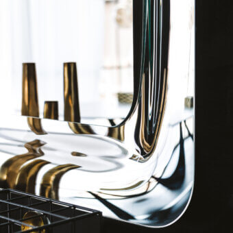Distinguished Cattelan Italia Glenn mirror with mirrored glass frame and sleek contemporary curved silhouette