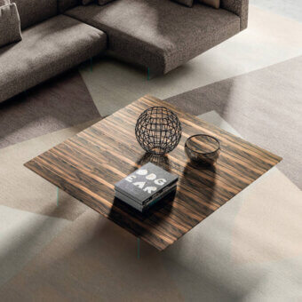 Lago air coffee table, wood grain, rectangular tabletop with books and geometric sphere, modern living room setting, natural light.