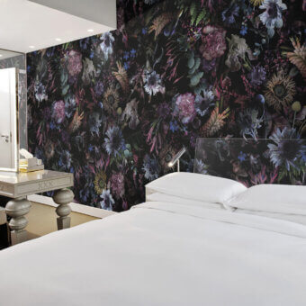 Exceptional LondonArt Rio Wallpaper captures vibrant energy with a bold floral design against a dramatic black background in blues, purples, and greens