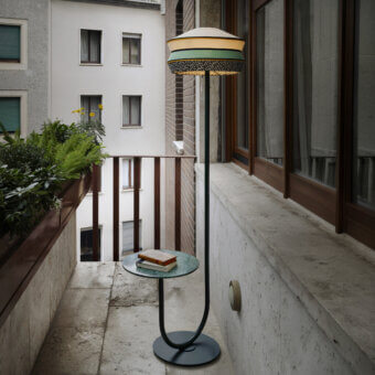 Distinguished Contardi Calypso Outdoor Floor Lamp with dark gray metal stem and multi-material lampshade in pale yellow, teal, white, and orange crafted with a marble side table