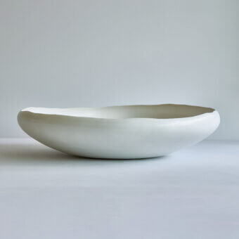 Exclusive Rina Menardi Luna centerpiece, a handcrafted decorative vessel sculpted in pale cream matte ceramic with organic form