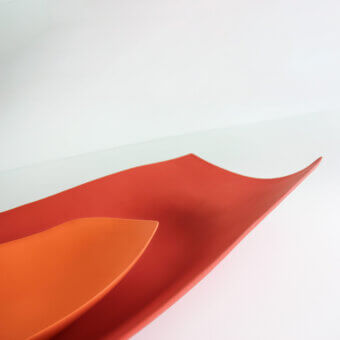 Distinguished Rina Menardi Vassoi Rettangolari Onde trays in vibrant orange-red with an organic undulating form and smooth matte finish