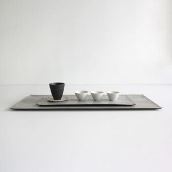 Exceptional Rina Menardi Vassoi Rettangolari centerpiece tray with textured dark gray finish and minimalist design