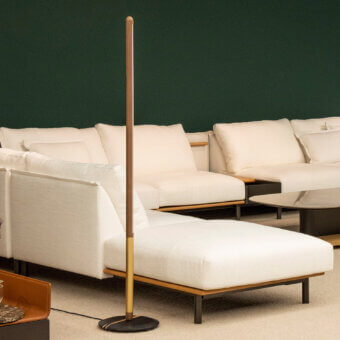 Premium Nomon Linea Uno floor lamp with light‑brown wood shaft, gold‑tinted metal section, gray disc base, matte satin finish