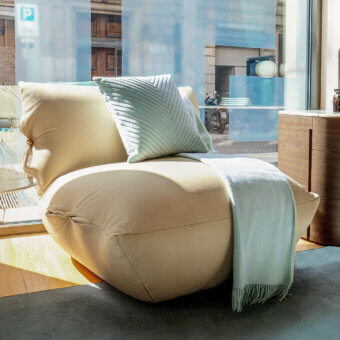 Distinctive Furla Casa Cherry Blossom lounge chair in creamy beige matte textile with golden-toned hemispherical logo details