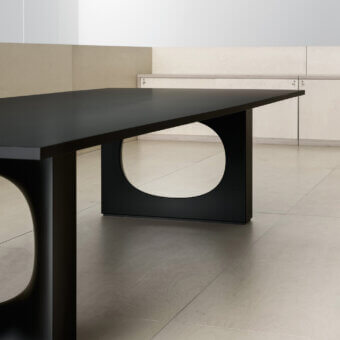 Architectural Kristalia Holo table crafted in matte black steel with curved oval opening and premium material rectangular top