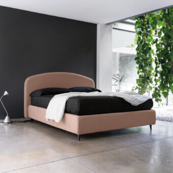 Sophisticated Noctis bed in dusty rose textile with crescent shaped headboard and dark metal legs