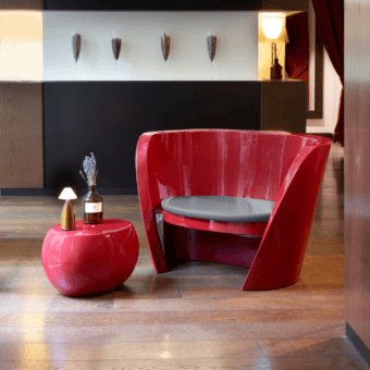 Elegant Slide Rap lounge chair in glossy red polyethylene with fluid sculptural silhouette and soft grey textile cushion